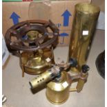 A large brass shell case; another; a paraffin lamp; an Optimus stove