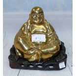 A Chinese brass Buddha on carved hardwood base