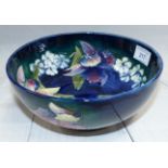 A Moorcroft circular bowl decorated with orchids against a blue/green ground, impressed and