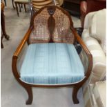 A 1930's mahogany cane back armchair with blue brocade seat