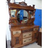 An Edwardian walnut mirror back sideboard with carved decoration, the raised back with display