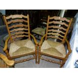 A set of 4 light oak dining chairs with rush seats and ladder backs