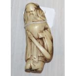 A Japanese netsuke of a bearded man with a sword, with label "Ex Collectis T.L. Elliott", 3½"