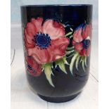 A Moorcroft cylindrical vase decorated with anemones against a deep blue ground, impressed and