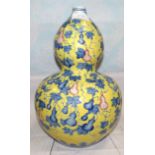 A Chinese porcelain double gourd shaped vase with underglaze blue decoration on raised yellow enamel