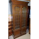 A 1930's oak full height bookcase enclosed by 2 leaded and 2 panelled doors