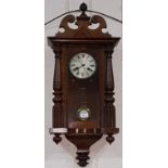 A 19th century spring driven Vienna wall clock with arched finial and turned side column, striking