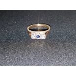 A 9 carat hallmarked gold dress ring set with a central sapphire and diamonds in illusion