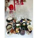 A selection of china Toby jugs; drinking glasses and red coloured pieces