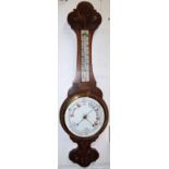 An Edwardian carved oak barometer with thermometer