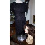 A black beaded cocktail dress; a mannequin bust with wig by J'adore