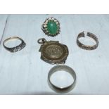 A ring set with a jade coloured stone; 3 other rings and a medallion