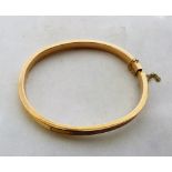 A hinged bangle in gold marked 14ct. 6.6g