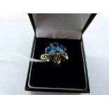 A three stone blue topaz and two stone diamond ring. In gold marked 375. 3.7g gross