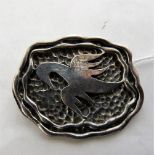 An oriental silver or white metal brooch of organic form with applied stylised bird