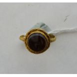 An antiquarian gold ring set with a hardstone with running animal matrix. Probably Romano-British.