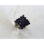 A sapphire cluster ring, set with 29 stones en-cabochon. In gold marked 375. Size M