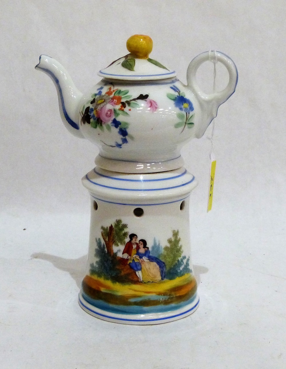 A 19th century French veilleuse teapot on burner stand, painted in colours with lovers in a garden