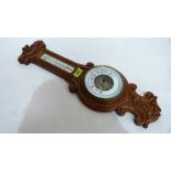 An oak aneroid barometer with temperature register. 23'' high