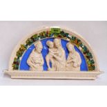 A 19th century Italian glazed pottery tympanum wall plaque, moulded in high relief with the Holy