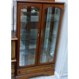 A modern china display cabinet with mirror back and base drawer. 32'' wide