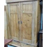 A 19th century continental pine armoire enclosed by a pair of panel doors over conforming base