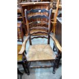 A 19th century Lancashire ladder-back elbow chair with rush seat