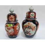 Two Japanese imari decorated jars with domed covers, the larger 11½'' high. Both damaged