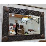 An oak wall mirror with carved blind fret frame and bevelled plate. 32½'' wide