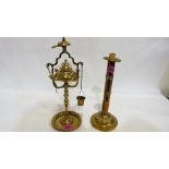 A brass ejector candlestick and a brass Roman style lamp