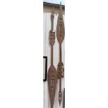 A pair of ethnic carved treen paddles. 67'' long