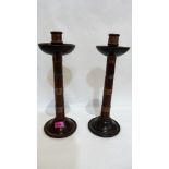 A pair of Arts and Crafts mahogany and copper candlesticks