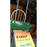 A rabbit cage, a lawn seeder and a stick back chair