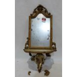 A 19th century French gilt composition looking glass, the scrolled surmount over arched plate and