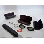 A pair of 1920' s motorbike goggles; three pairs of cased spectacles and another case