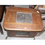 An early 20th century oak coal box with inlet Art-Nouveau repousse metal panels of stylised poppies.