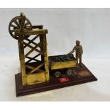 A brass model of a colliery lift engine with coal truck and miner. 13'' wide