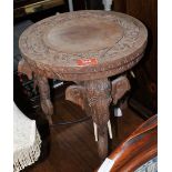 An Indian hardwood stool on elephant carved supports