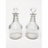 TWO 19TH CENTURY CLEAR GLASS DECANTERS AND STOPPERS each of mallet form and with three rings to
