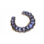 CREATED SAPPHIRE AND GEM SET BROOCH of horseshoe shape,