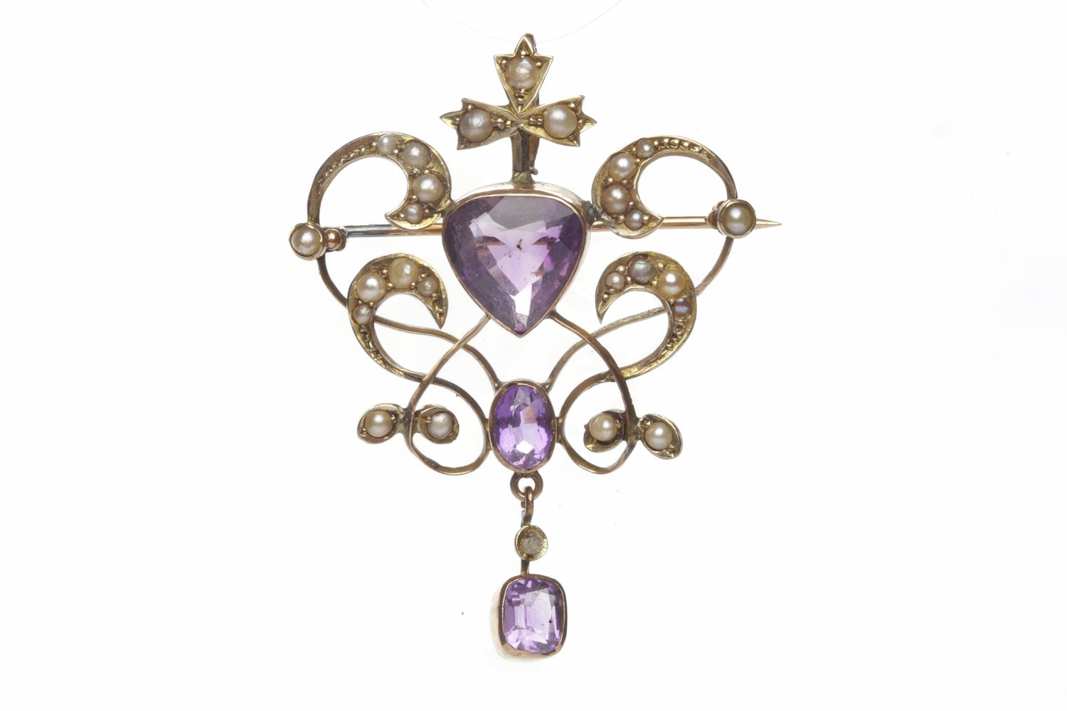 EDWARDIAN AMETHYST AND SEED PEARL SET BROOCH PENDANT of sinuous openwork form and set with a