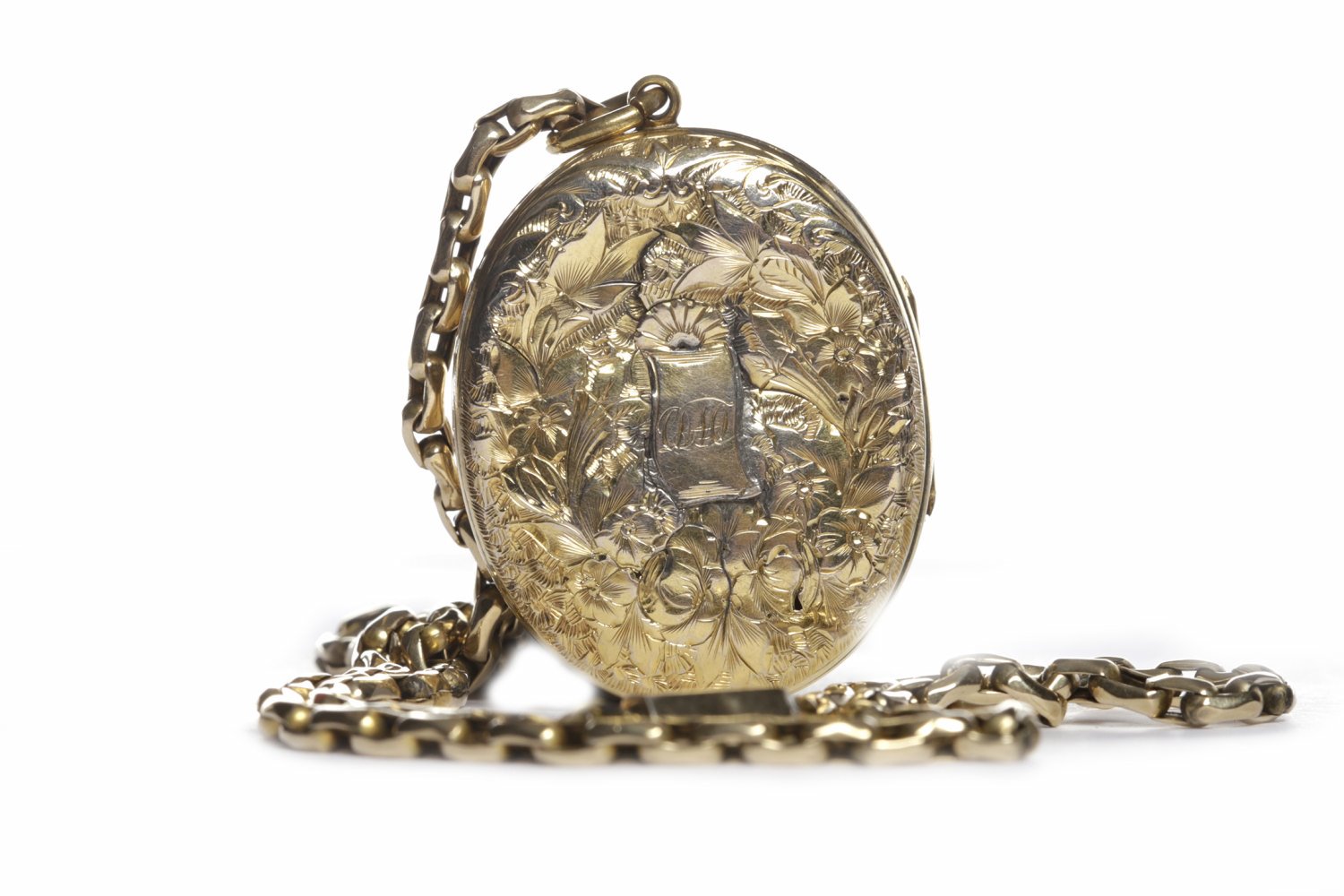 VICTORIAN GOLD PLATED LOCKET ON CHAIN the locket of oval form and with scrollwork engraving,