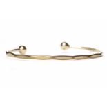 NINE CARAT GOLD TORQUE BANGLE with a diameter of 6.5cm, weighing approximately 9.