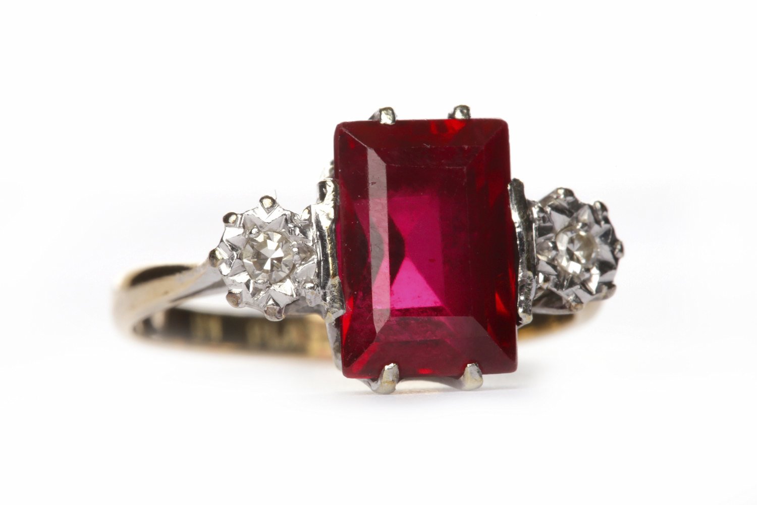 CREATED RUBY AND DIAMOND THREE STONE RING the central rectangular step cut created ruby flanked by