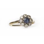 SAPPHIRE AND DIAMOND CLUSTER RING the central round sapphire surrounded by round brilliant cut