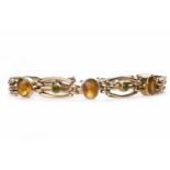 NINE CARAT GOLD GEM SET GATE LINK BRACELET set with oval orange gems and round green gems,