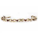 NINE CARAT GOLD GARNET BRACELET set with eight round garnets, 17.5cm long, 7.