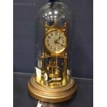 GUSTAVE BECKER BRASS ANNIVERSARY CLOCK with circular Arabic numeral dial, with weighted pendulum,