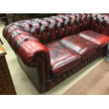 GROUP OF BUTTONED OXBLOOD LEATHER DRAWING ROOM FURNITURE comprising three seat Chesterfield-style