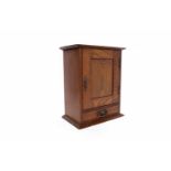 20TH CENTURY OAK TOBACCO CABINET the panelled hinged door and lid enclosing a shelf for tobacco jar